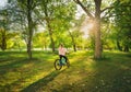 Woman riding a mountain bike near green trees at sunset in sprin Royalty Free Stock Photo