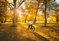 Woman riding a mountain bike and orange trees at sunset in autumn Royalty Free Stock Photo