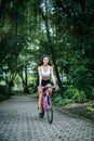 Woman riding a road bike. Portrait of young beautiful woman on pink bike Royalty Free Stock Photo