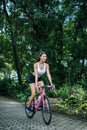 Woman riding a road bike. Portrait of young beautiful woman on pink bike Royalty Free Stock Photo