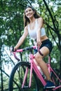 Woman riding a road bike. Portrait of young beautiful woman on pink bike Royalty Free Stock Photo