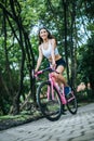 Woman riding a road bike. Portrait of young beautiful woman on pink bike Royalty Free Stock Photo