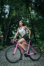 Woman riding a road bike. Portrait of young beautiful woman on pink bike Royalty Free Stock Photo