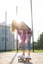 Woman riding a skateboard on street. Skater girl on a longboard. Cool female skateboarder at sunset. Carefree female Royalty Free Stock Photo