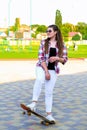 Woman riding a skateboard on street. Skater girl on a longboard. Cool female skateboarder at sunset. Carefree female Royalty Free Stock Photo