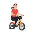 Woman riding a small yellow tricycle with training wheels Royalty Free Stock Photo