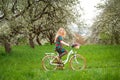 Woman riding vintage white bicycle with flowers basket Royalty Free Stock Photo