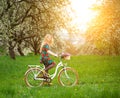 Woman riding vintage white bicycle with flowers basket Royalty Free Stock Photo