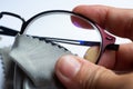 Woman right hand cleaning shortsighted or nearsighted eyeglasses by microfibre cleaning cloths, On white background, Close up