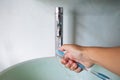 Woman right hand washing toothbrush on green washbasin, Water flowing from faucet, Bathroom concept