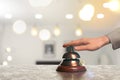 Woman ringing hotel service bell on blurred background, closeup