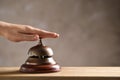 Woman ringing hotel service bell at table, closeup. Space for text Royalty Free Stock Photo