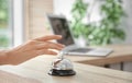 Woman ringing service bell on reception des