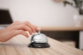 Woman ringing service bell on reception desk in hotel Royalty Free Stock Photo