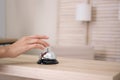 Woman ringing service bell on reception desk in hotel Royalty Free Stock Photo