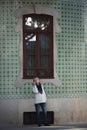 A woman rings her cell phone while standing outside a traditional house in downtown Porto. Royalty Free Stock Photo