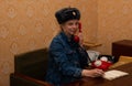 Woman rings from a Russian retro red telephone with a hat on her head Royalty Free Stock Photo