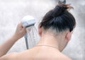 Woman Rinses Neck with a Hand Held Shower Head.