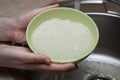 Woman rinsing rice in bowl under running water Royalty Free Stock Photo