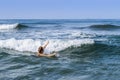 A woman rising hand under an incoming wave in the Indian Ocean