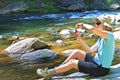 Woman at a River Taking Picture