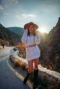 Woman road mountain. A woman in a white sweater, black boots and a hat walks along a winding alpine path between the Royalty Free Stock Photo