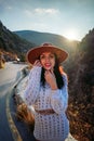 Woman road mountain. A woman in a white sweater, black boots and a hat walks along a winding alpine path between the Royalty Free Stock Photo