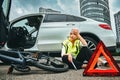 Woman in road vest repairing car and a bicycle Royalty Free Stock Photo