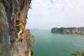 Woman rock climber climbing at seaside mountain cliff Royalty Free Stock Photo