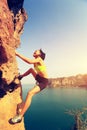 Woman rock climber climbing at seaside mountain rock wall Royalty Free Stock Photo