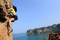 Woman rock climber climbing at seaside mountain rock Royalty Free Stock Photo