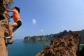 Woman rock climber climbing at seaside mountain rock Royalty Free Stock Photo