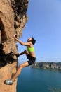 Woman rock climber climbing at seaside mountain rock Royalty Free Stock Photo