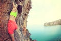 Woman rock climber climbing at seaside mountain rock Royalty Free Stock Photo