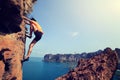 Woman rock climber climbing at seaside mountain rock Royalty Free Stock Photo