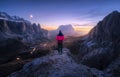 Woman on the rock and mountain peaks at night in autumn