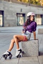 Woman in roller skates sitting and holding a bottle of water Royalty Free Stock Photo