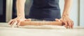 Woman rolling dough on wooden table with wooden rolling pin Royalty Free Stock Photo