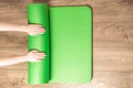 Woman rolling her Yoga mat after a training - top view. Concept healthy lifestyle, sport