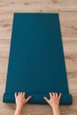 Woman rolling out her yoga mat in a studio