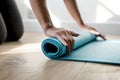 Woman rolling yoga mat after finishing with the exercise