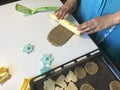 A woman rolls out the dough to make a shortbread cookie with sesame. Before shipment to the oven. Nearby lie molds for shaping the