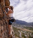 Woman, rope and rock climbing for fitness in outdoors, challenge and mountain for training. Female person, cliff and