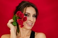 A woman with a rose flower. Beauty portrait of a woman with a beautiful rose flower, makeup, hairstyle on a red background. Women Royalty Free Stock Photo