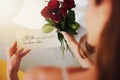 Woman, roses and note with gift in bedroom on birthday, celebration and valentines day event in home. Girl, reading