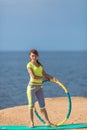 Woman rotates hula hoop on summer beach Royalty Free Stock Photo