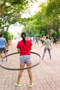 Woman rotates hula hoop to exercise in the public park Royalty Free Stock Photo