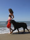 Woman and rottweiler on the beach Royalty Free Stock Photo