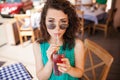 Woman in round sunglasses with cocktail at cafe terrace having fun Royalty Free Stock Photo