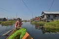 Woman rowing canoe Inle Lake floating house Royalty Free Stock Photo